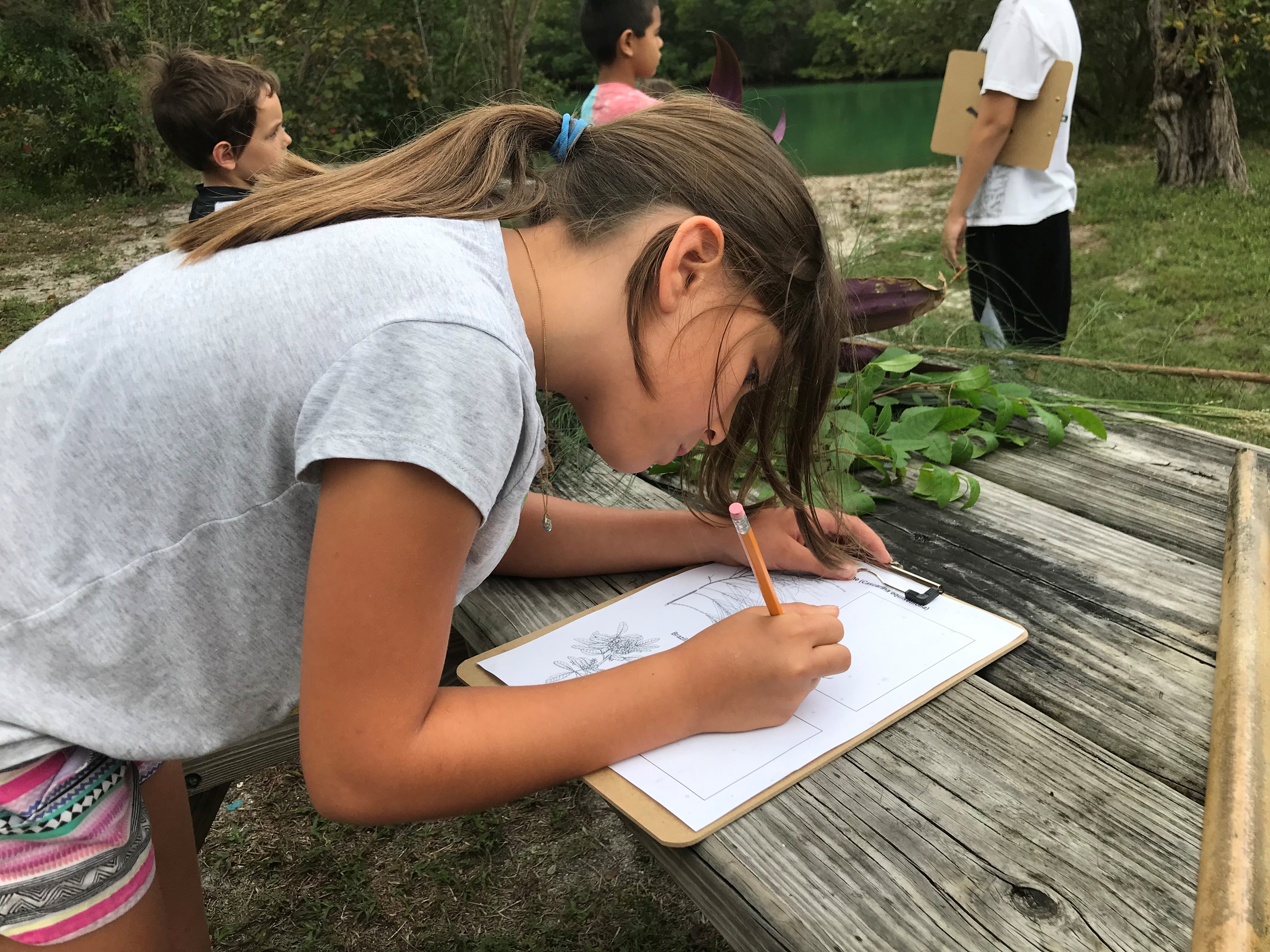 A young visitor logging observations at a Florida state park