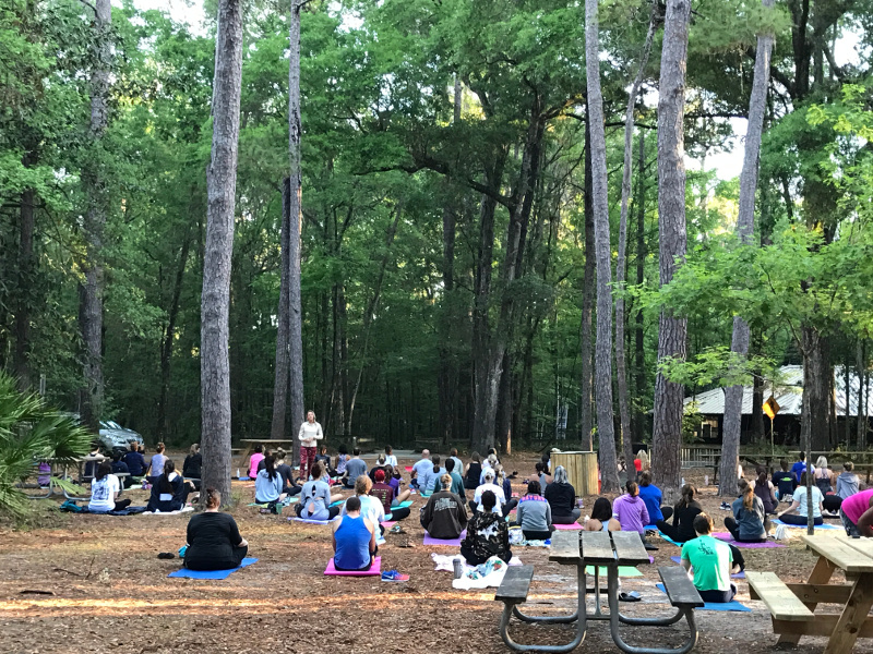 Visitors are seen sitting during a yoga program at Devil's Millhopper State Park.