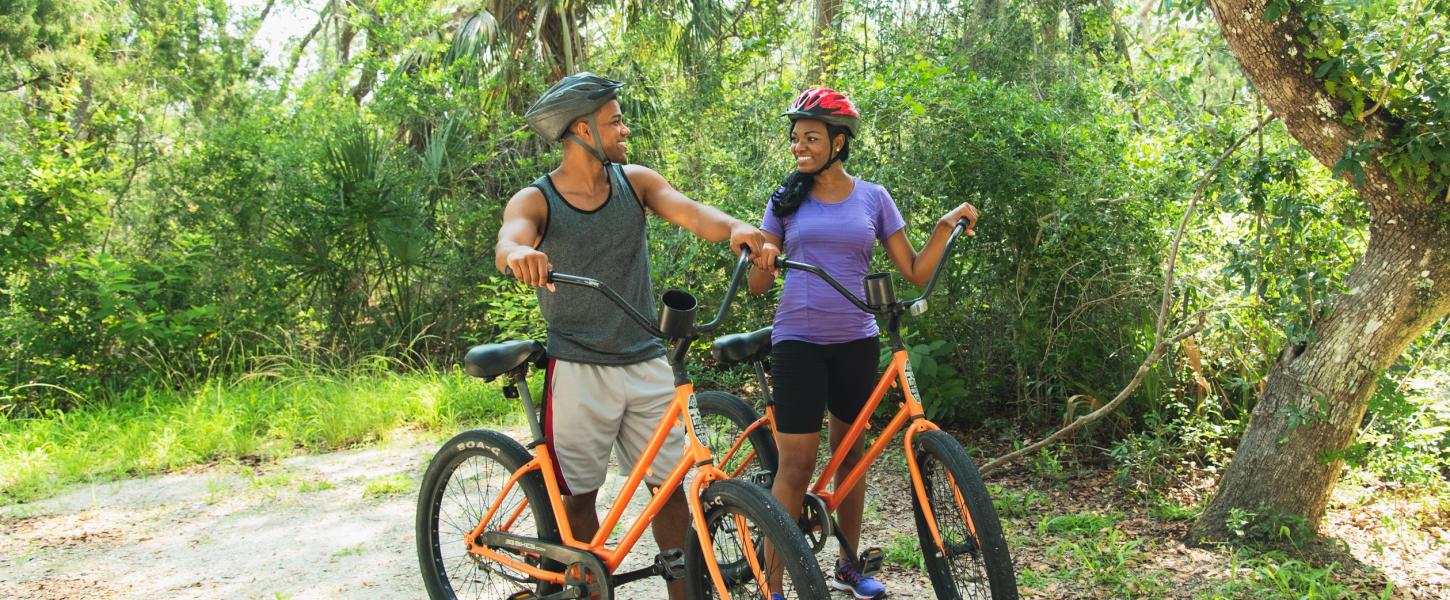 Two people riding bicycles at Anastasia State Park.
