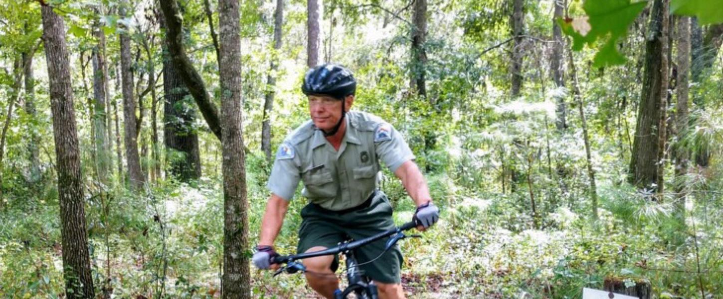John patrolling the trails on a bicycle.