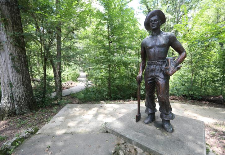 Statue on Civilian Conservation Corp member holding an ax in one hand. 