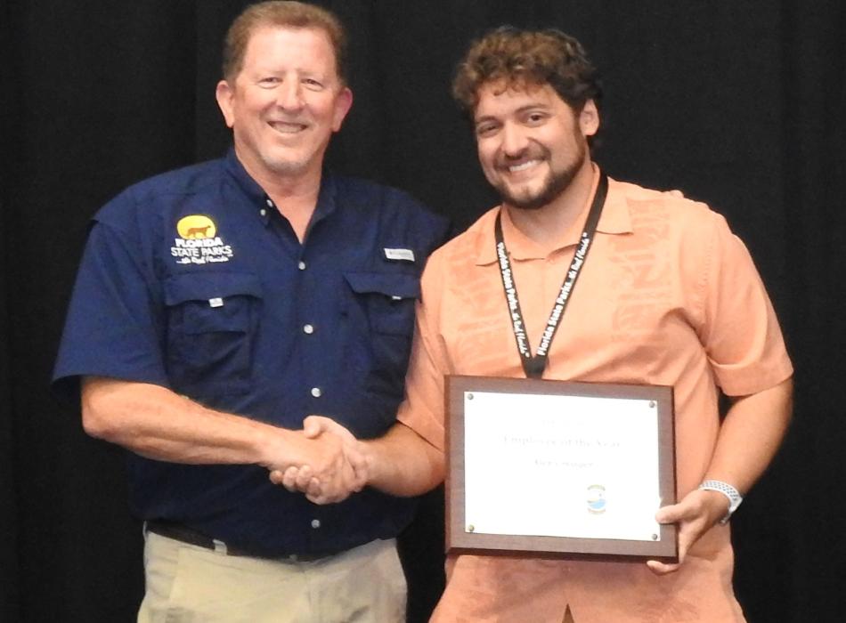 Director Chuck Hatcher presents 2021 Employee of the Year Award to Alex Creager.