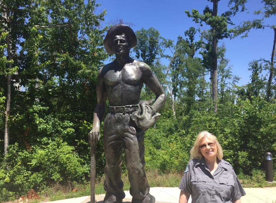 Volunteer Eleanor Anglin standing by the Civilian Conservation Corps Statue