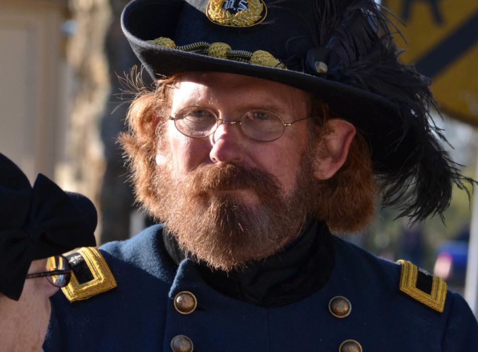 a man in a feather cavalry hat and a union general's uniform