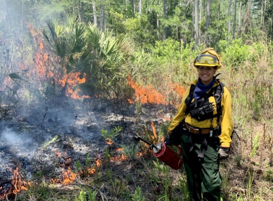 Salena Alberti holds a drip torch while working on a prescribed fire.