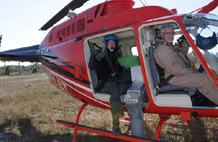 Prescribed burn team members in a helicopter.