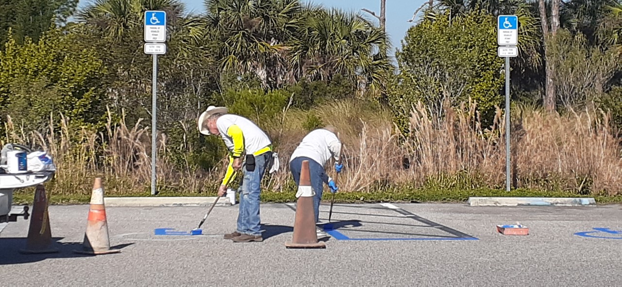 Two people working in a parking lot 
