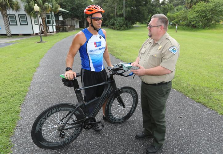 A park ranger talks with a bicyclist on the Nature Coast State Trail.