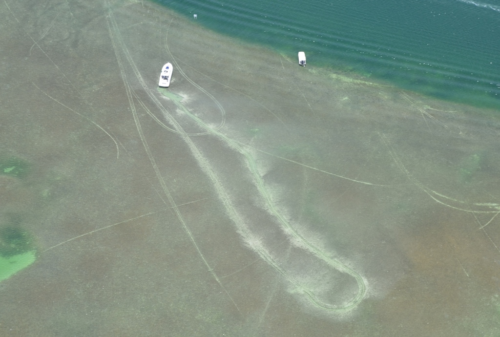 aerial of boat grounding and propeller scar