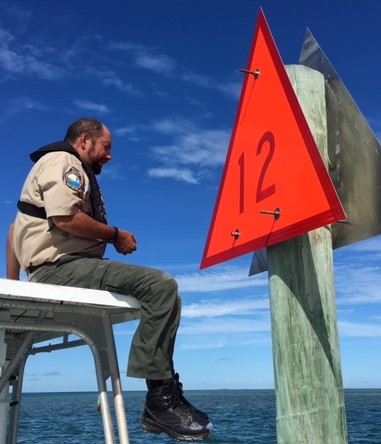 A park ranger installing a navigational marker.