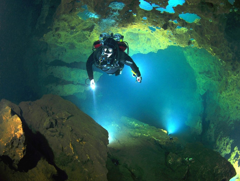 image of a cave diver navigating with a light at manatee springs state park.