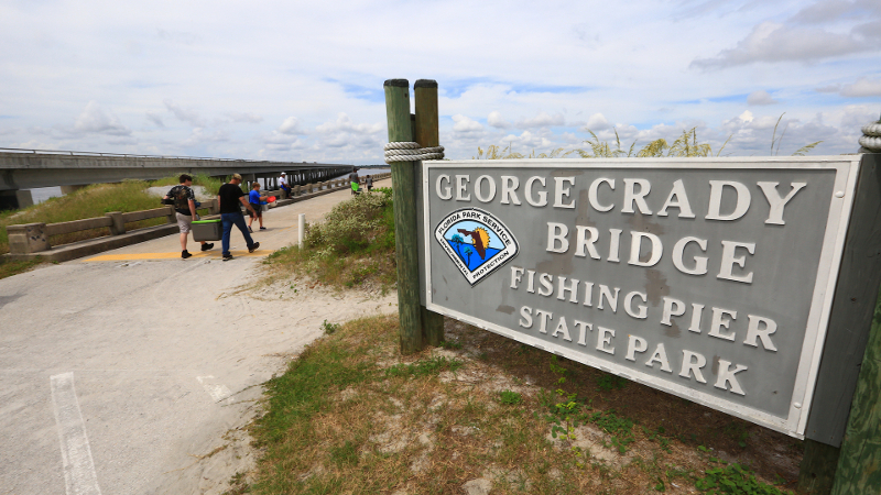 a large sign that reads George Crady Bridge Fishing Pier State Park