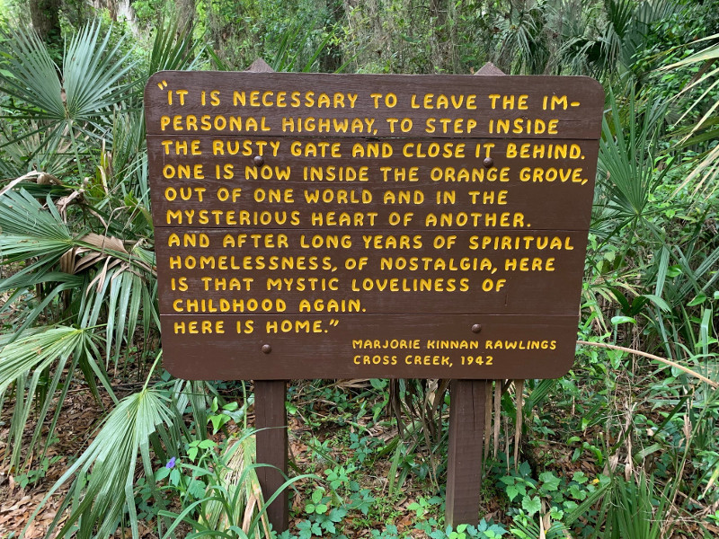 a brown sign reads a quote by marjorie kinnan rawlings in yellow text