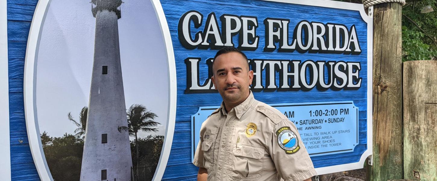 Jorge stands in front of the park sign.