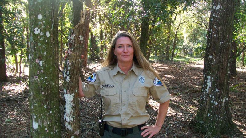 Park Ranger Jane Cummings in the forest smiling at the camera 