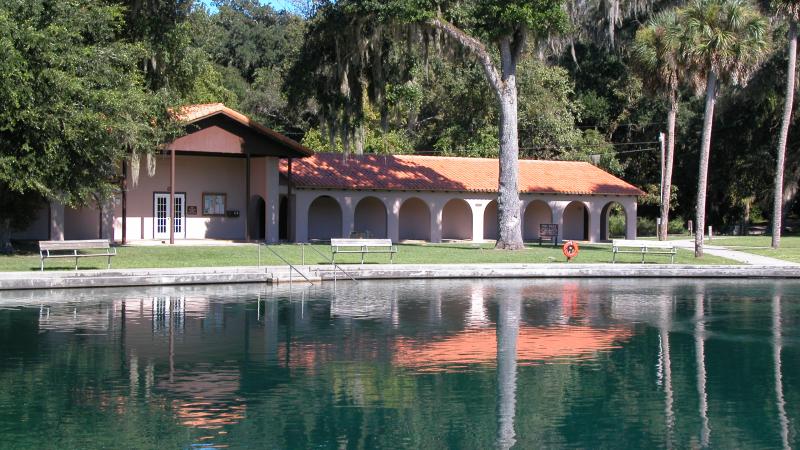 A view of the welcome center at de leon springs in front of the water.