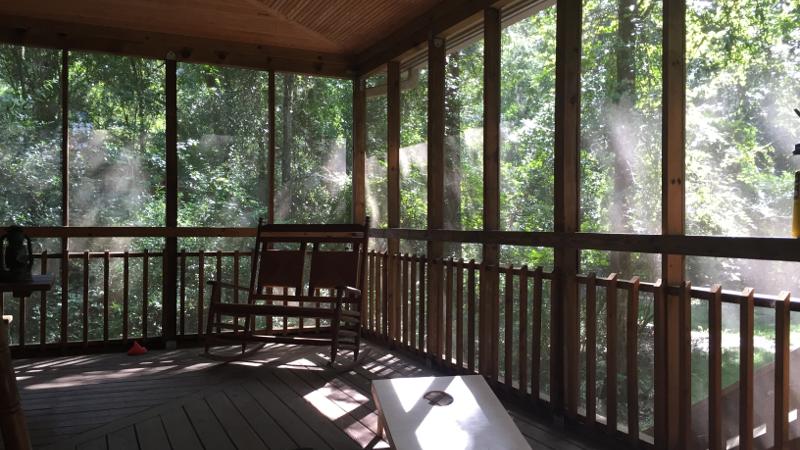 Image of the porch of a cabin with a rocking chair and cornhole board  at Suwannee River State Park.