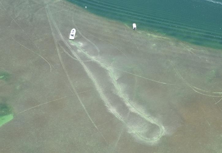 aerial of boat grounding and propeller scar