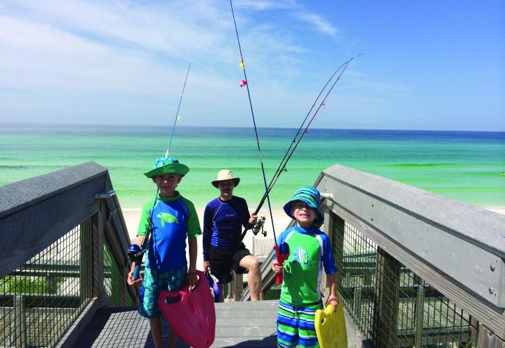Kids with fishing gear standing on the boardwalk