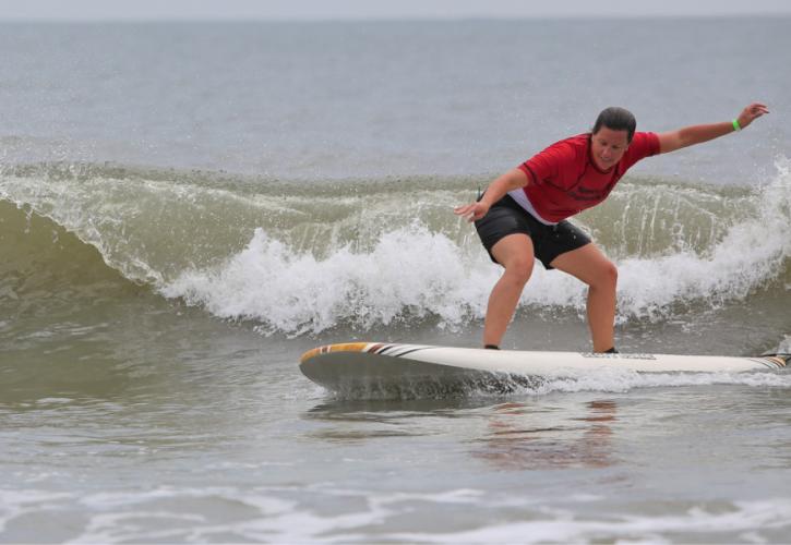 A woman in red is seen surfing off the beach of Little Talbot Island State Park