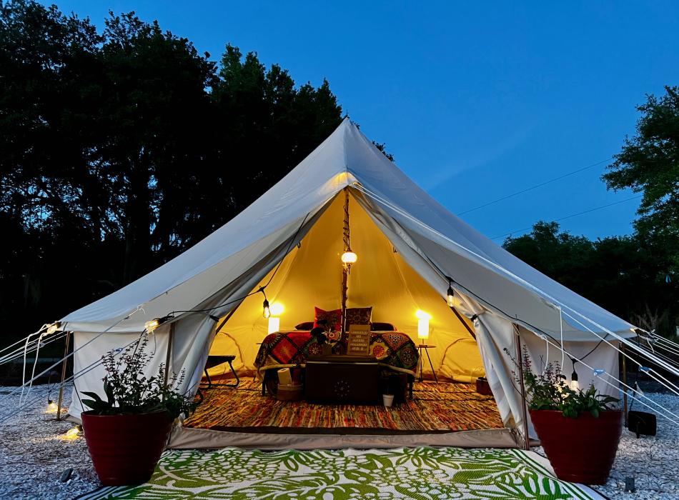 Glamping tent with lights on.