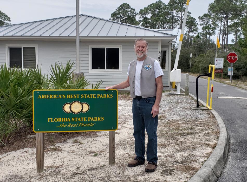 Marney standing by the entrance sign to Grayton Beach.
