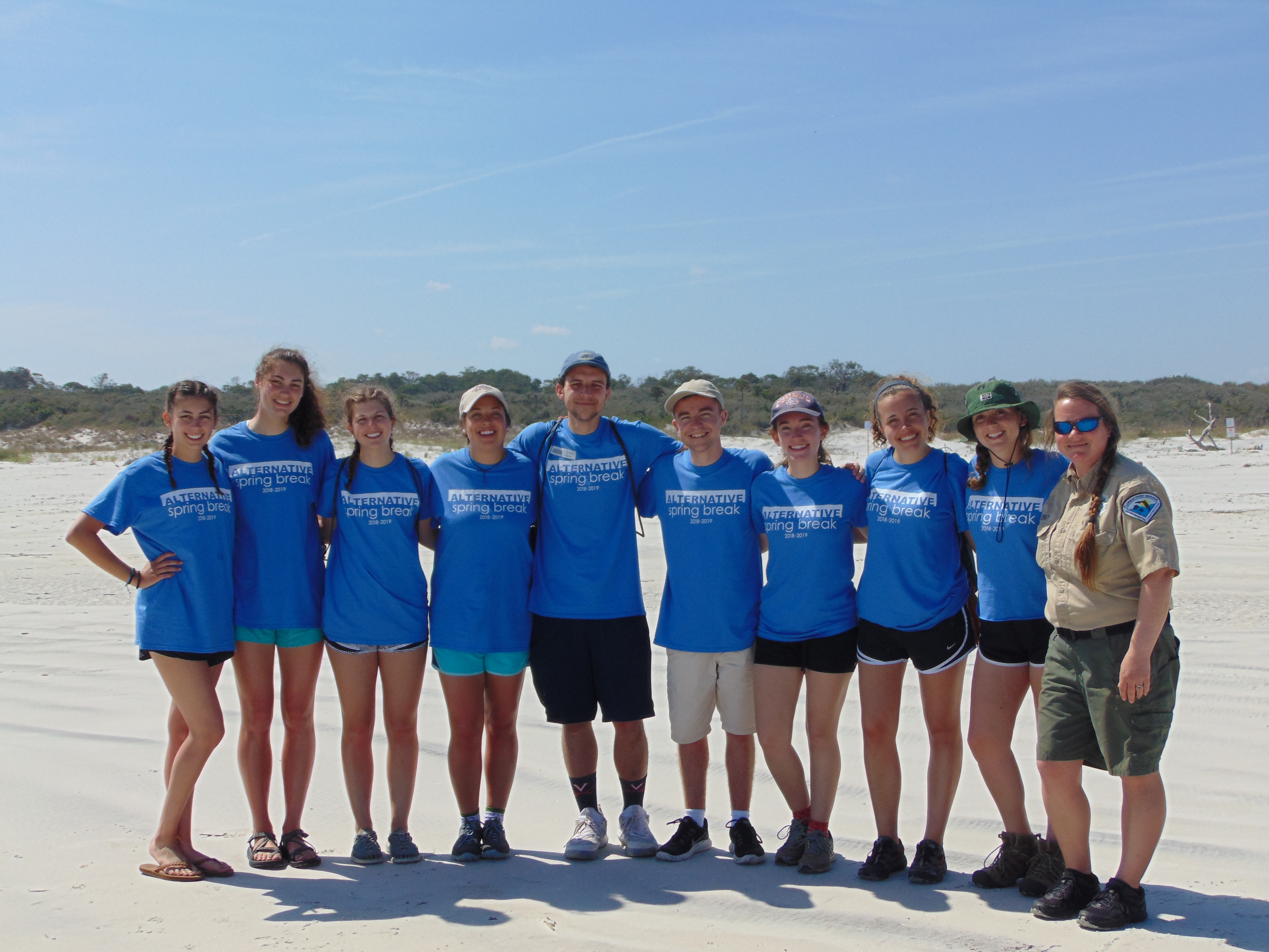 Volunteers pose for a photo with the park ranger at an alt spring break event in Jacksonville.