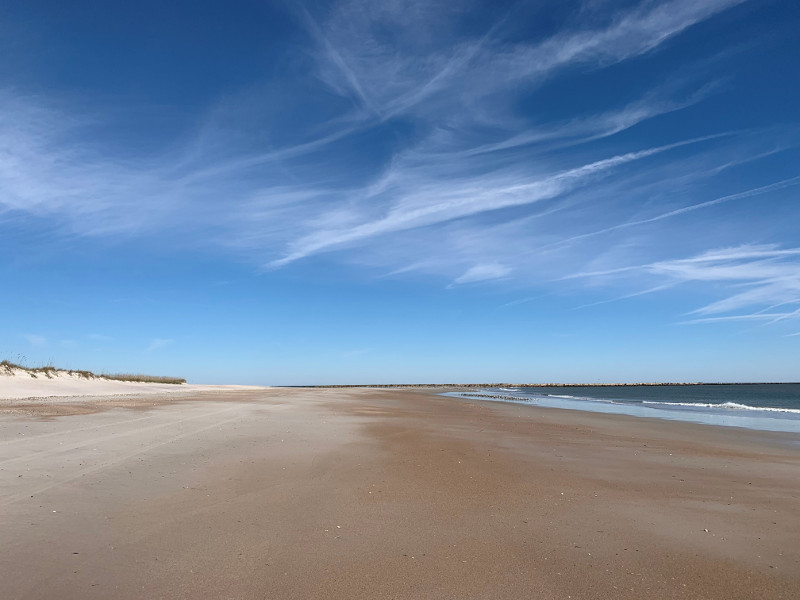 a white sand beach stretches into the horizon alongside the atlantic ocean.