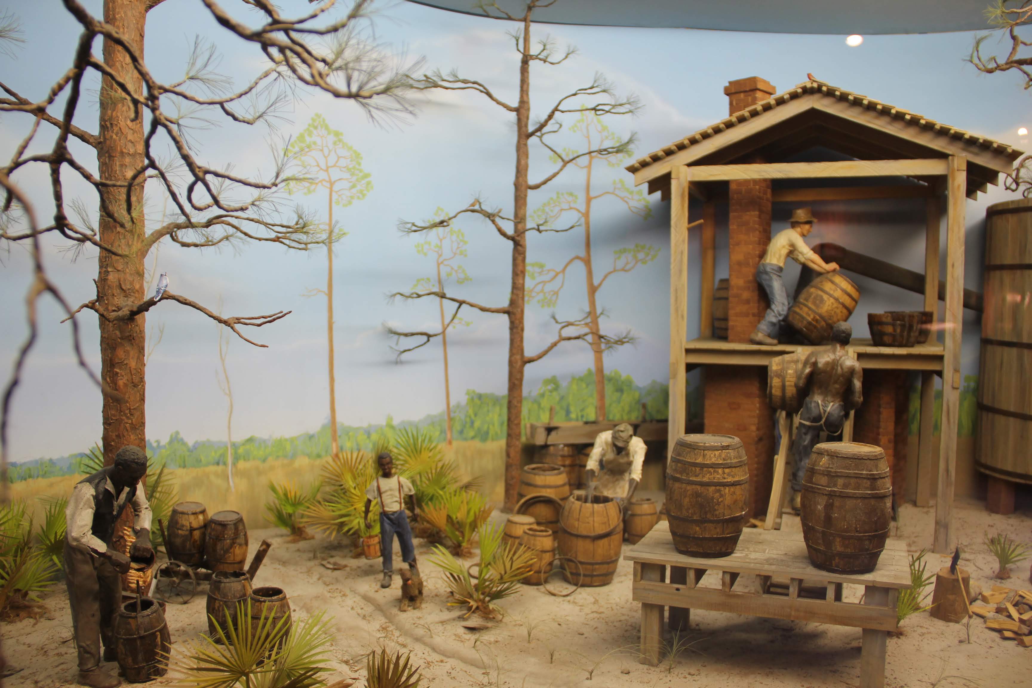 a diorama of people working a turpentine still in Florida in the 1800's.