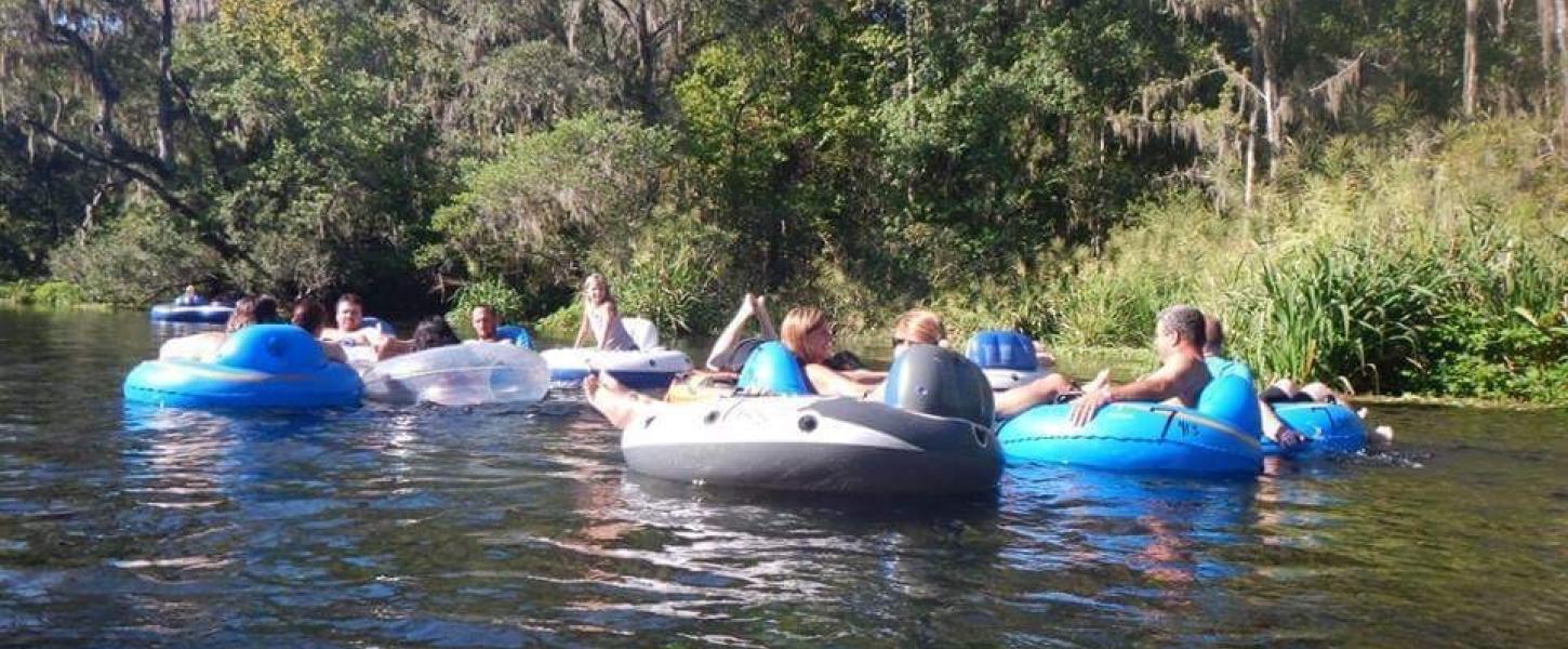 A group of people use colorful inflated tubes to float down the Ichetucknee River.