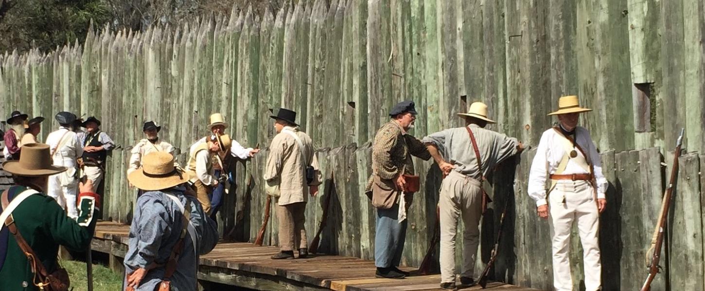 A view of reenactors lined up along the wall of the fort.