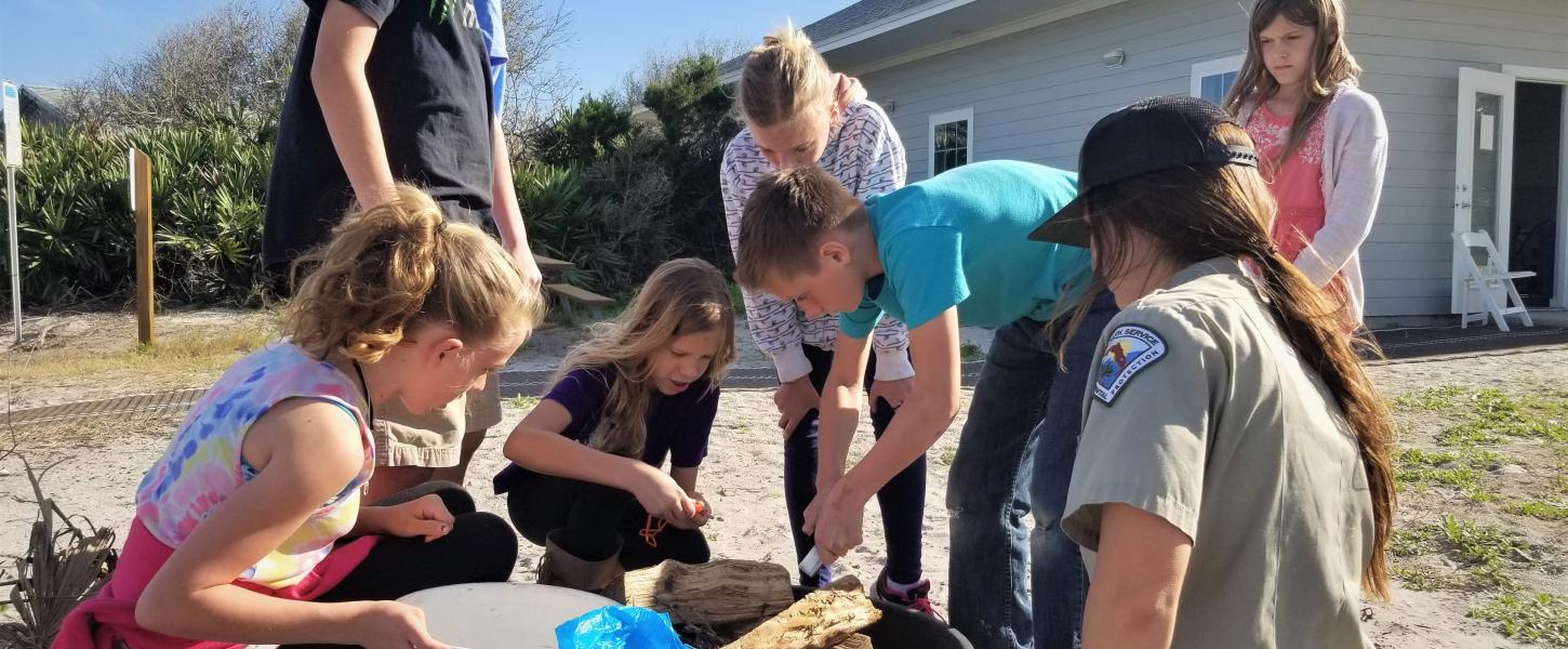 Junior Rangers learn how to safely build a campfire with a ranger at Anastasia State Park. 