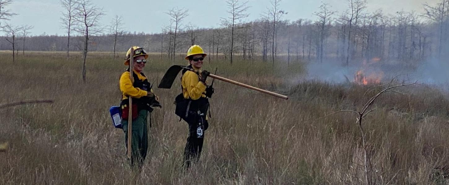 Two people monitor a prescribed fire at Fakahatchee Strand Preserve.