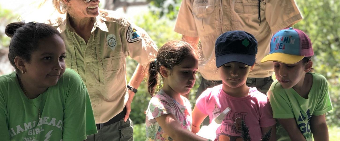 Group of girl scouts look at watershed model. 