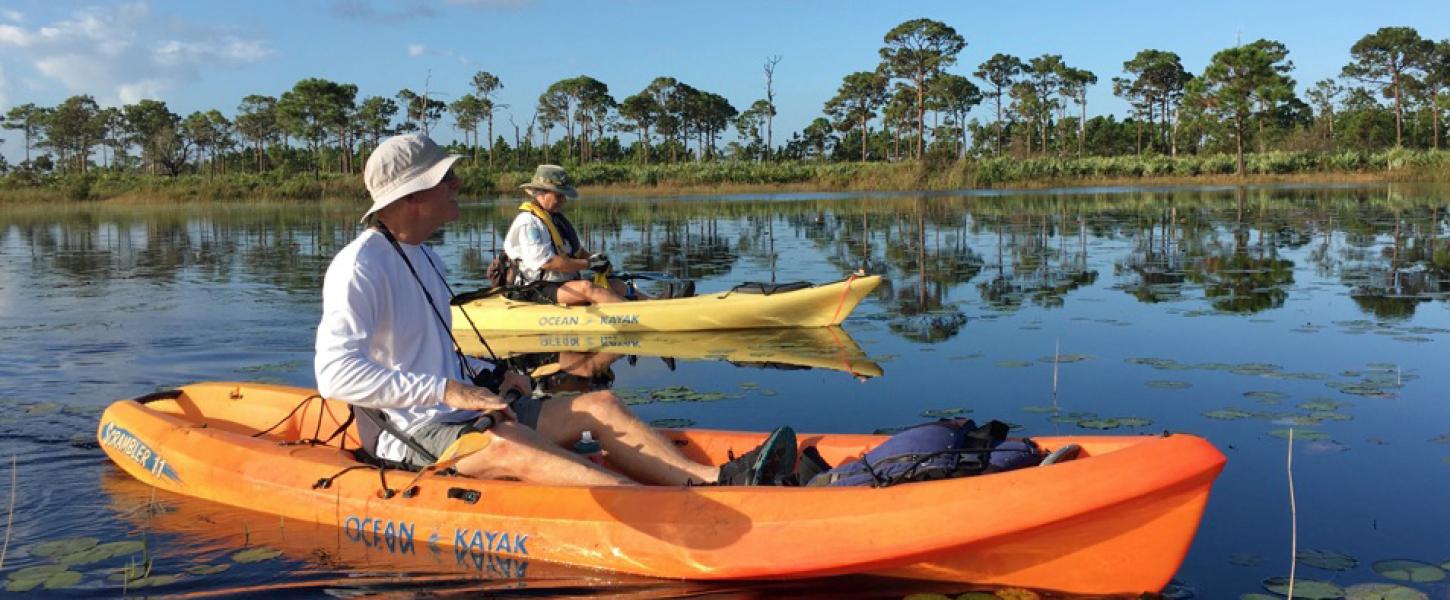A male visitor resting in a kayak on a freshwater marsh.