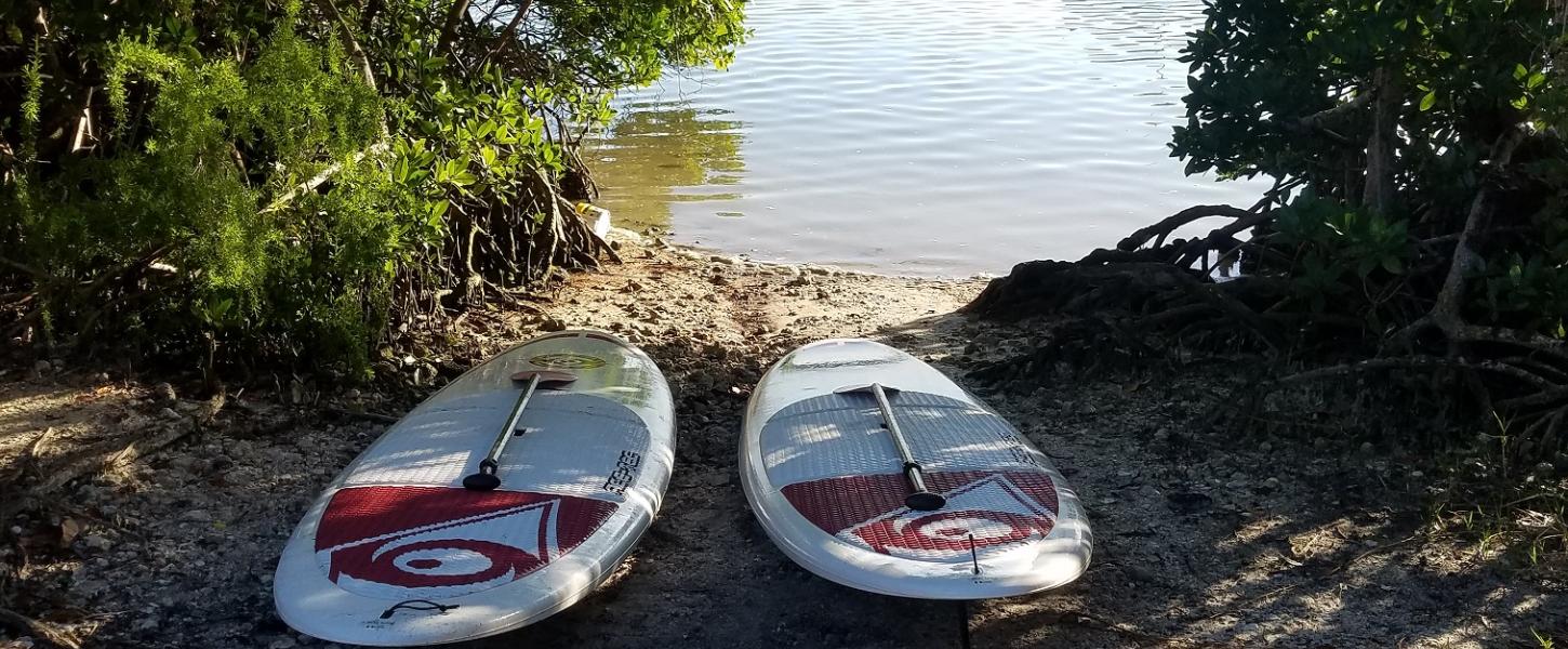 Two paddle boards at launch area by the water
