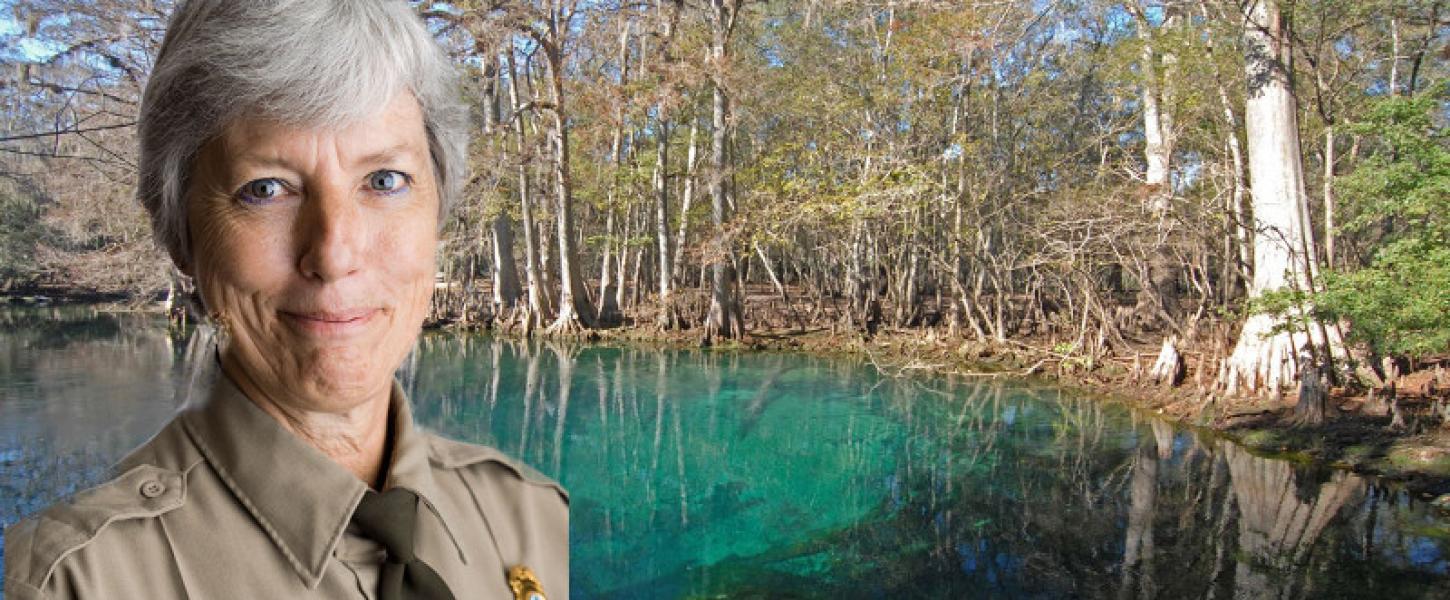 a park ranger in uniform in front of a blue spring