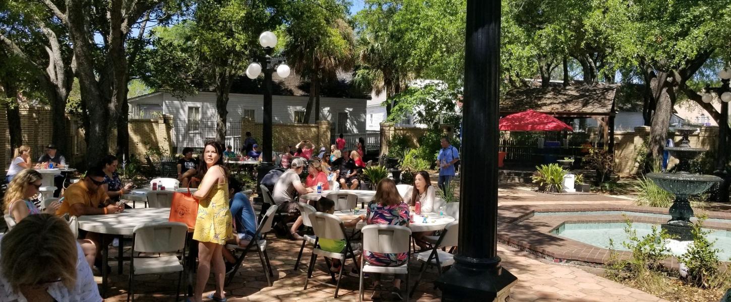 A view of people at an event in the Ybor City Museum garden.