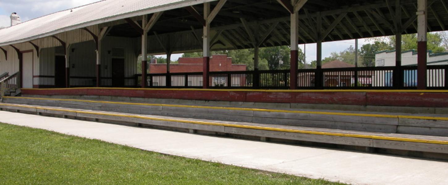 a long roofed train platform next to a paved trail