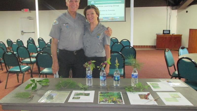 Volunteers Bruce and Darlene standing by a table with interpretive materials on it
