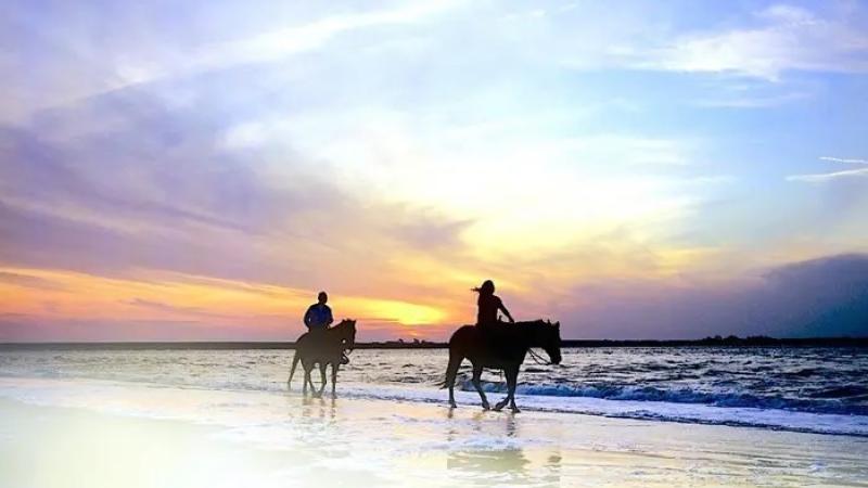 Two people ride horses at Amelia Island State Park.