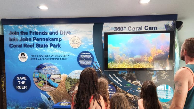 Visitors watch the coral cam from the exhibit inside the visitor center.