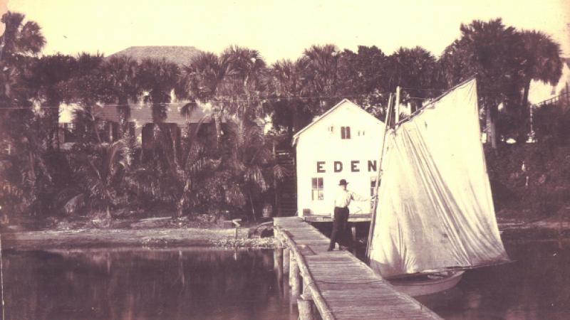 A boathouse and dock rest on the shoreline of the Indian River Lagoon.