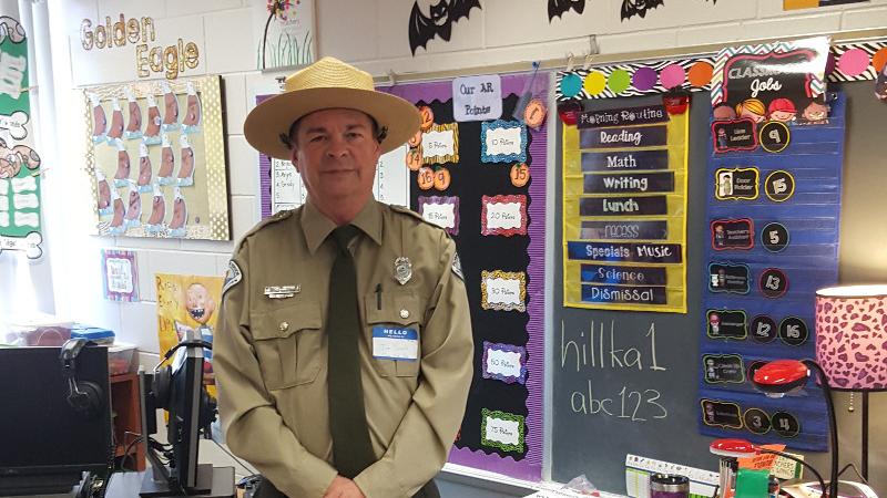 a park ranger in uniform stands in the middle of school classroom