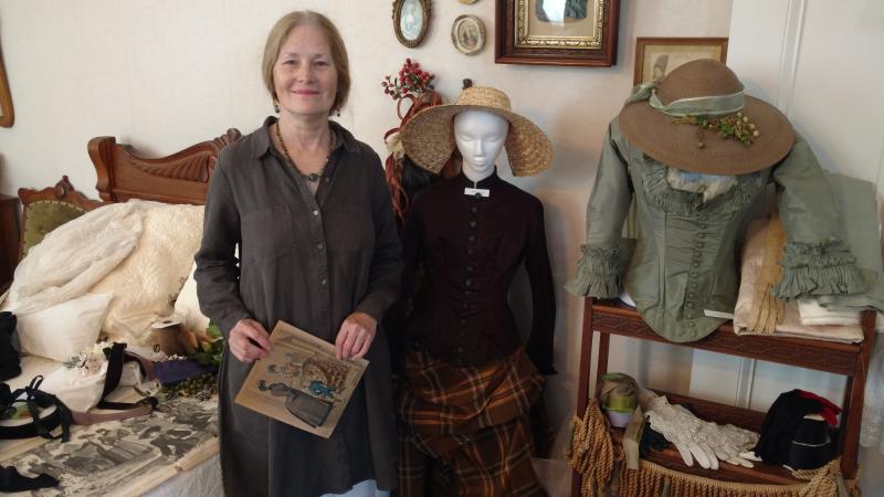 Volunteer Linda White organizes display of women's fashion that she donated to the park. 