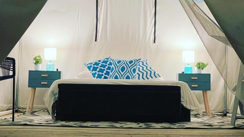 Bed and amenities at glamping tent