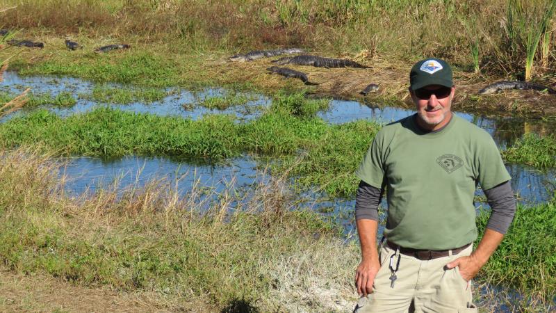 Park staff Steve Kline with alligators behind him