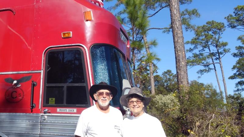 Volunteers Jimmy and Sadie Clay standing in front of their red bus known as the "Iron Horse".