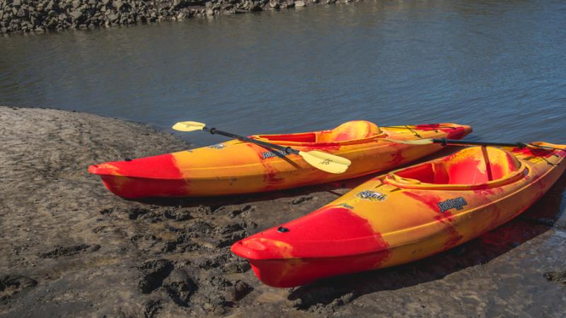 Two red and yellow kayaks rest in the sand at Little Talbot Island State Park.