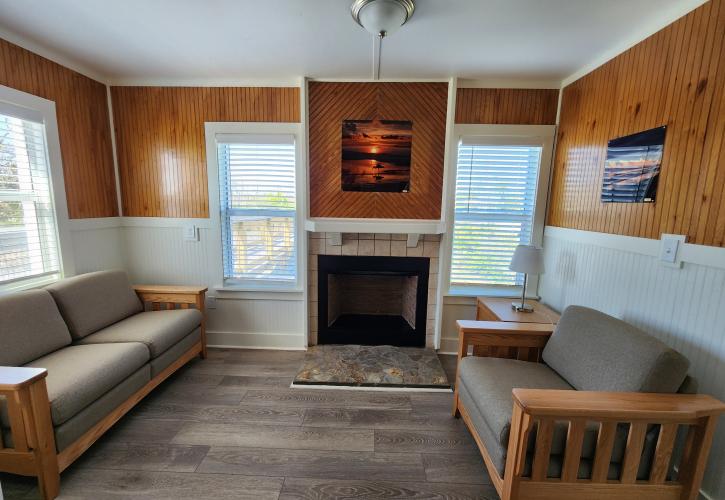 Fireplace with two sofas in the living room of Cabin 1.